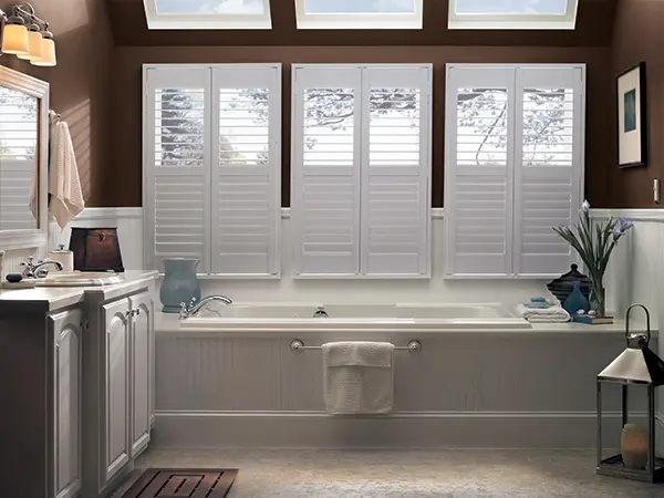 A bathroom with three windows and a tub.